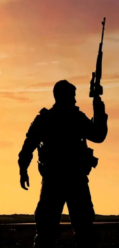 Silhouette of a soldier at sunset with vibrant orange sky.