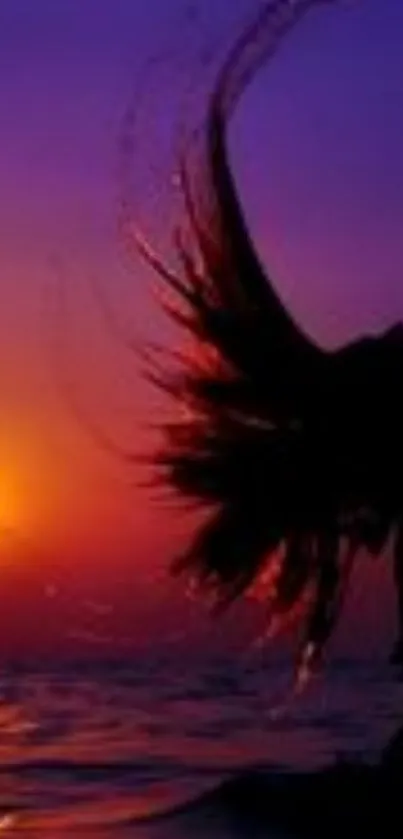 Silhouette of hair flipping at sunset over ocean with purple sky.