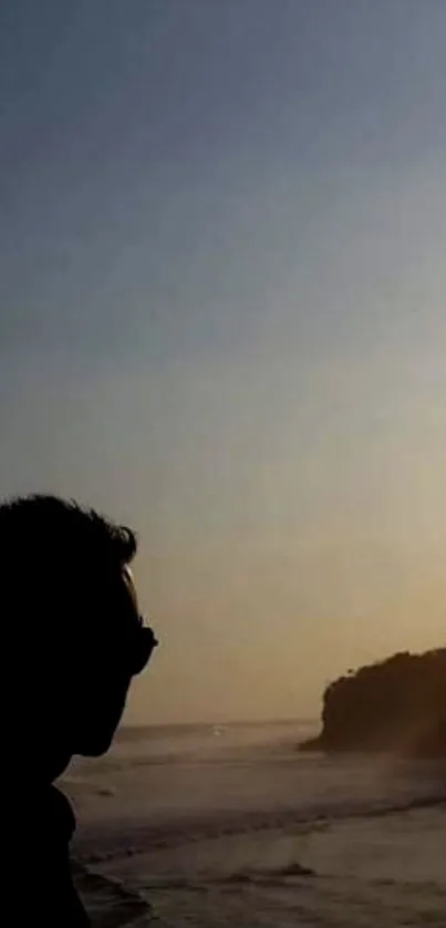 Silhouette of a person at a sunset beach with scenic sky.