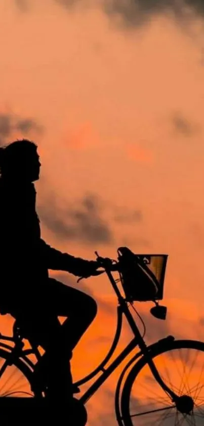 Silhouette of a cyclist against a vivid orange sunset.