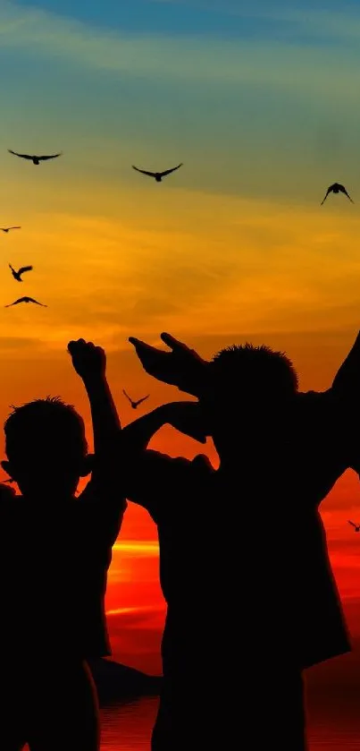 Kids' silhouettes play against a vibrant sunset sky.