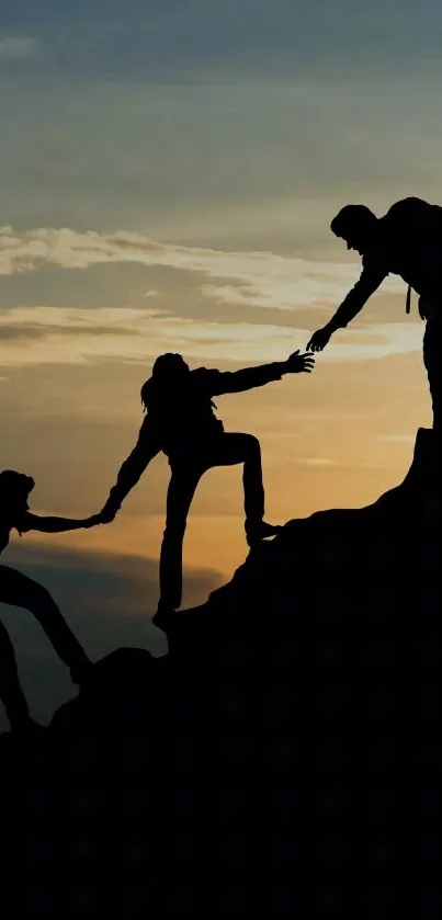 Silhouette of teamwork on a mountain during sunset.