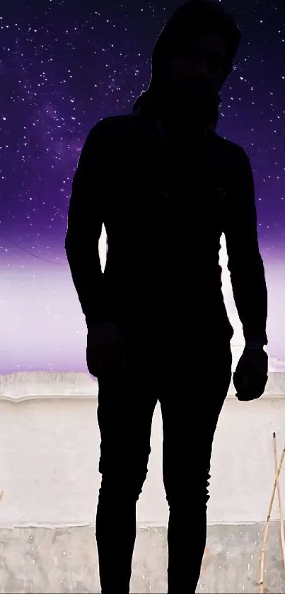 Silhouette stands under a starry purple night sky.