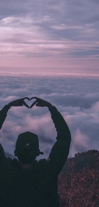 Silhouette making heart shape against purple sunset clouds.