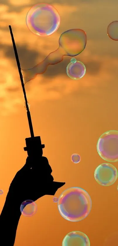 Silhouette blowing bubbles against a golden sunset backdrop.