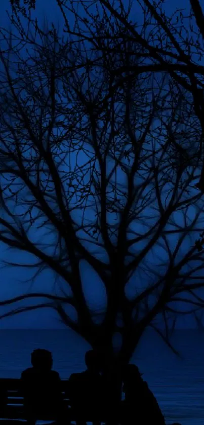 Silhouetted tree against a dark blue dusk sky, creating a serene mobile wallpaper.