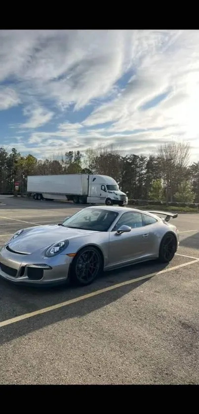 Sleek silver car parked under a bright cloudy sky in picturesque setting.