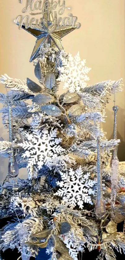 Silver Christmas tree with snowflakes and star decorations.