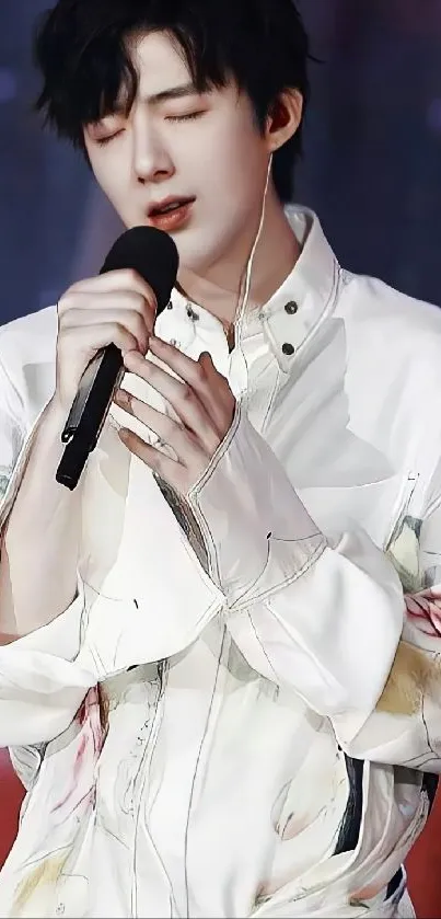 Singer in white shirt holding a microphone on stage.