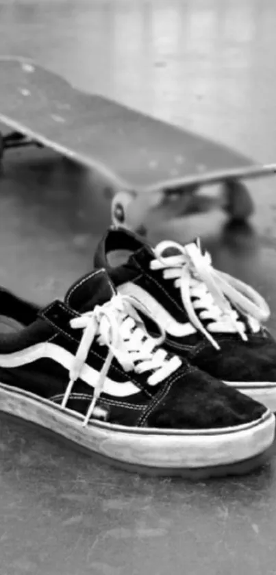 Black and white snapshot of sneakers with skateboard.