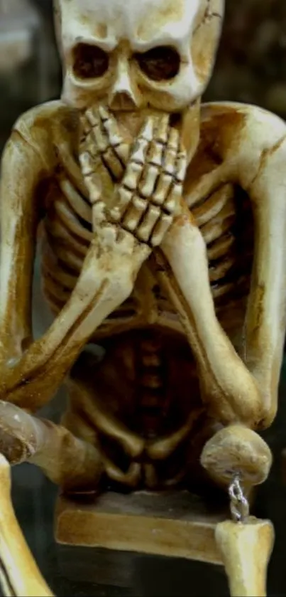 Skeleton sculpture wallpaper with hands covering mouth.