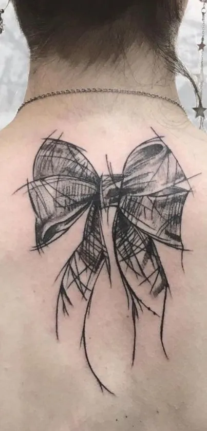 Back with elegant sketch bow tattoo design.