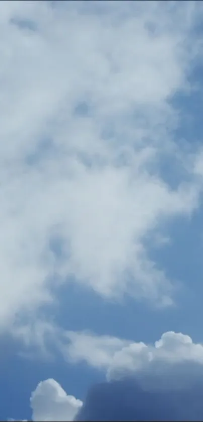 Serene blue sky with white fluffy clouds wallpaper.