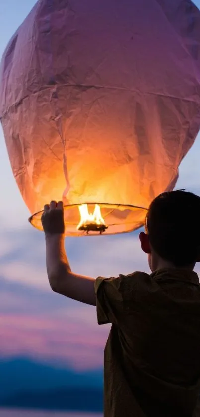 Boy releasing lantern at twilight.