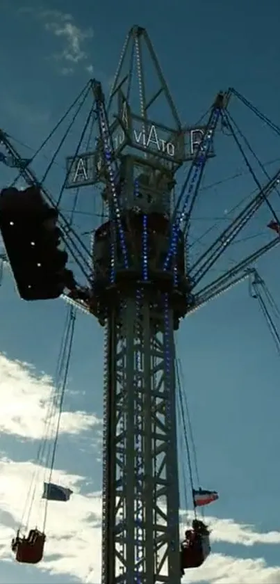 Silhouette of a carnival swing ride against a sunset sky.