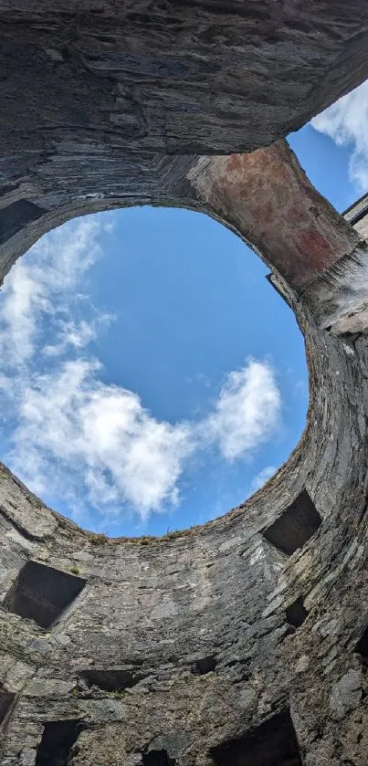 View of sky through ancient stone ruins with circular opening.