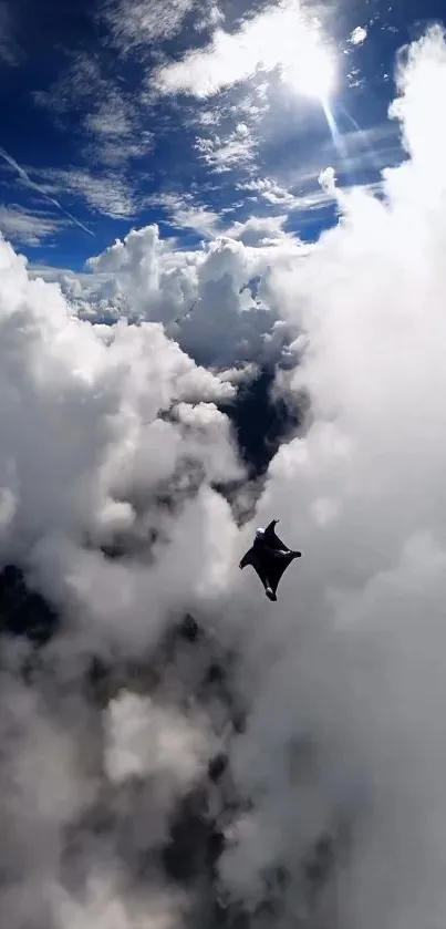 Skydiver in clouds with blue sky background.