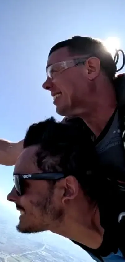 Two people skydiving in clear blue sky, capturing the thrill of high-altitude adventure.