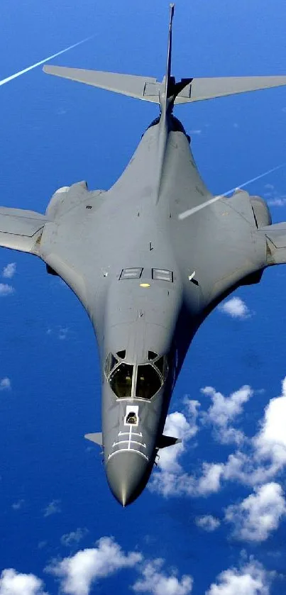 Sleek aircraft flying high above a vibrant blue sky with scattered clouds.