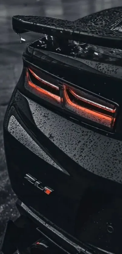 Sleek black car with glowing tail lights in the rain.