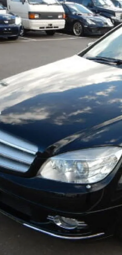 Sleek black car with reflective surface in showroom setting.