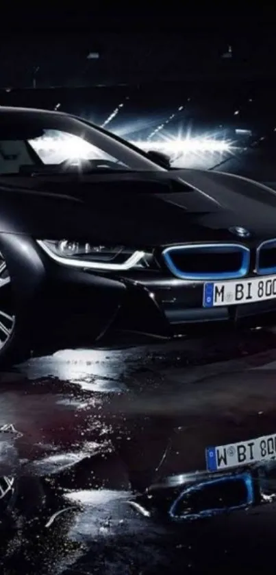 Sleek luxury black car reflected on a wet surface at night.