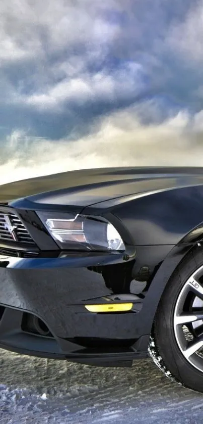 Sleek black sports car with dramatic cloudy sky.