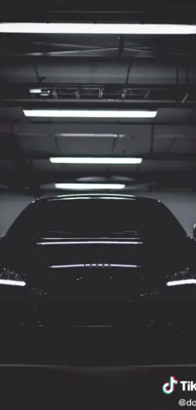 Sleek black car in dark garage with glowing headlights.