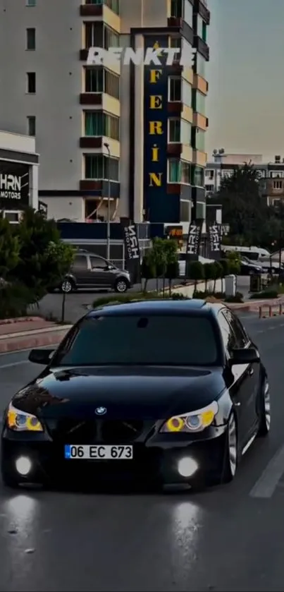 Black car driving on city street at dusk.