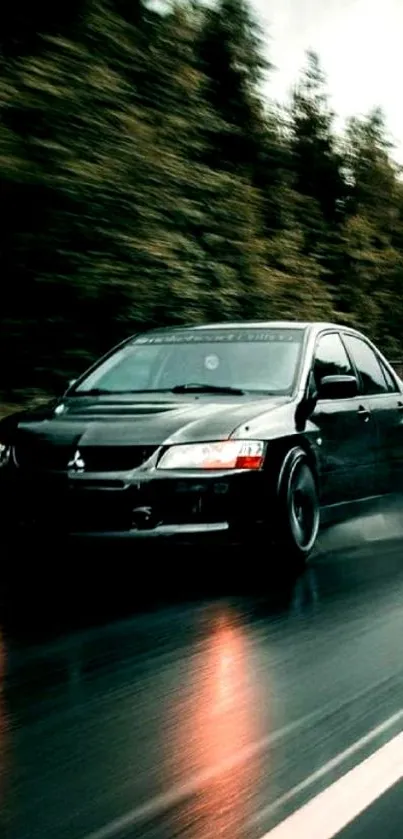 Black car driving fast on a rainy forest road.