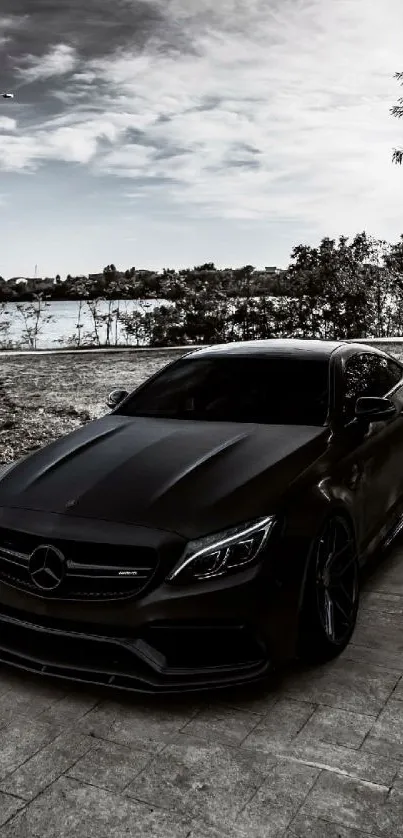 Black luxury car parked on lakeside road at dusk, with sleek modern design.