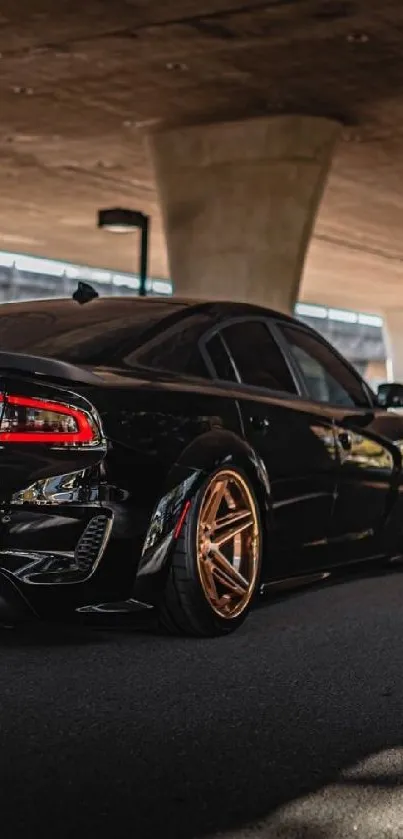 Sleek black car under urban bridge wallpaper.