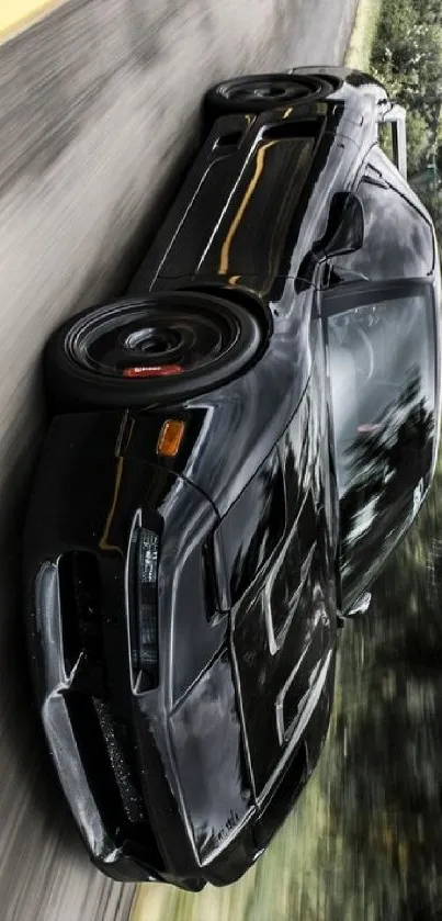 Sleek black car speeding on an empty road with blurred background.