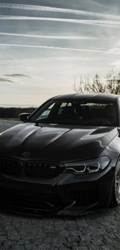 Sleek black car under dramatic sky