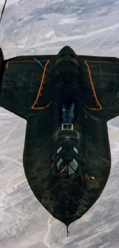 A sleek black jet soaring through the sky viewed from above.