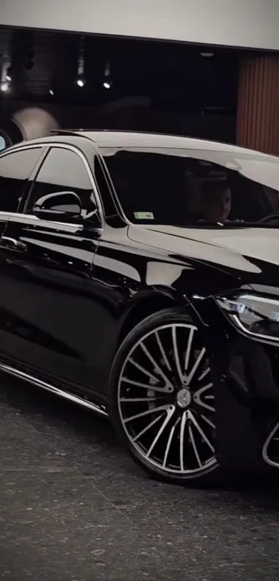 Sleek black luxury car parked indoors.