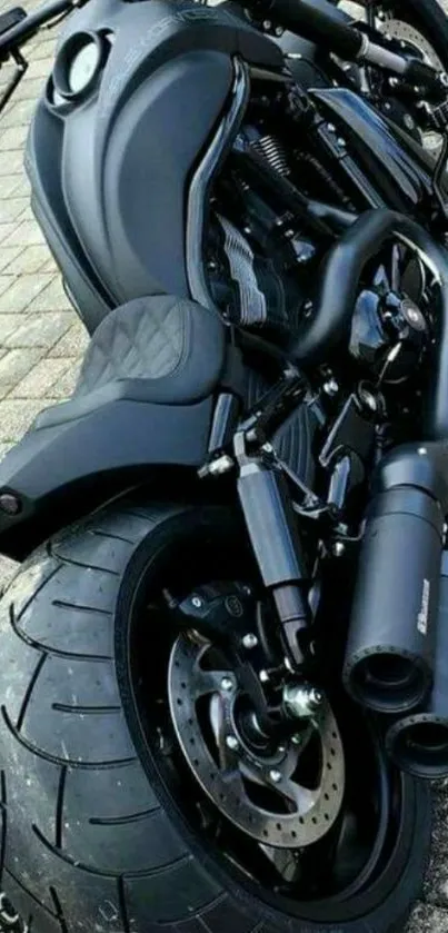 Sleek black motorcycle on tiled pavement.