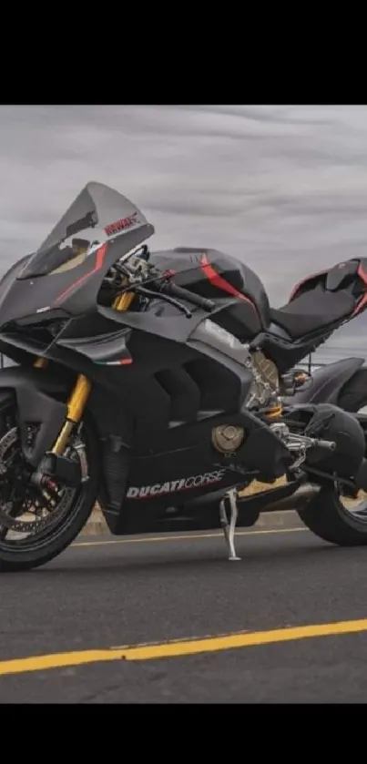 Sleek black motorcycle on open road with dynamic sky backdrop.