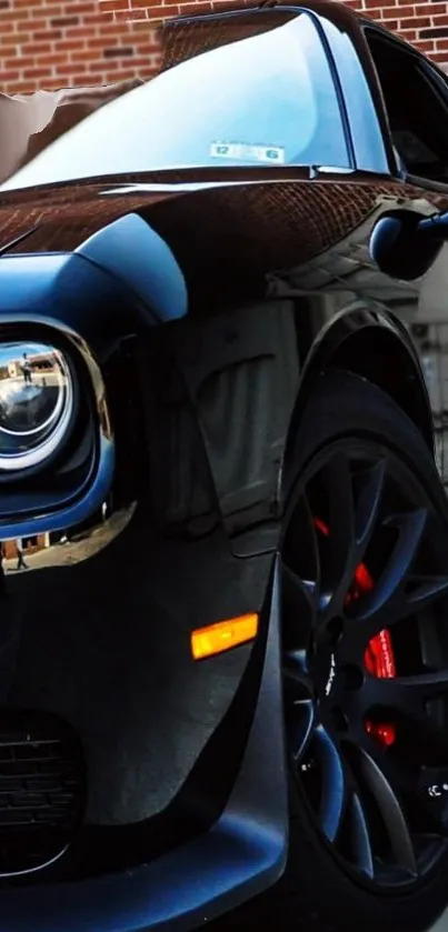 Sleek black muscle car parked against a brick wall, showcasing a powerful design.