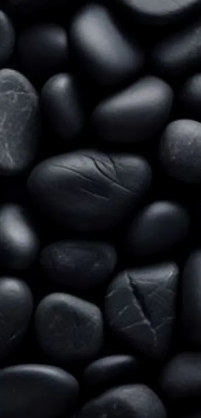 Black pebbles creating a smooth and natural phone wallpaper.
