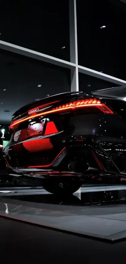 Sleek black sports car with bright taillights in a showroom.