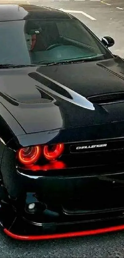 Sleek black sports car with red accents on pavement.