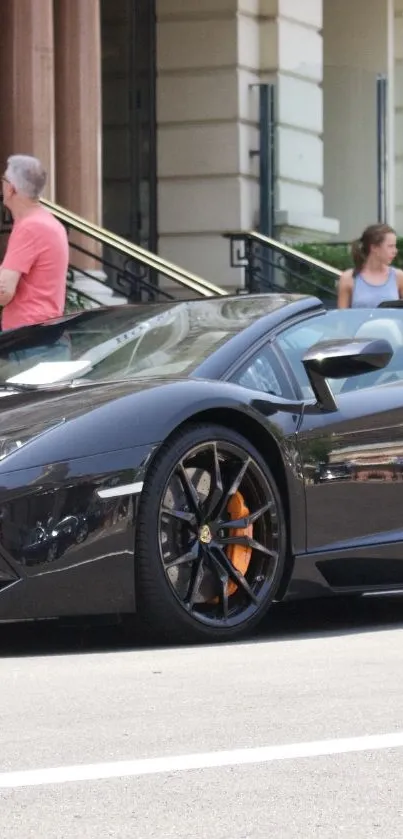 Sleek black sports car parked on street with elegant design.