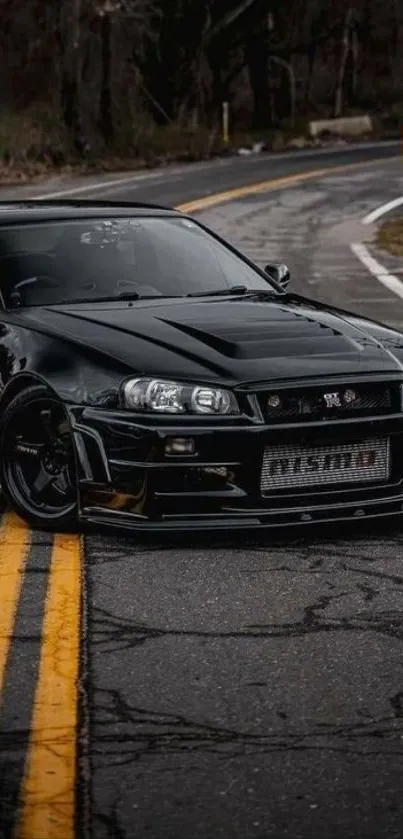 Sleek black sports car on winding road.