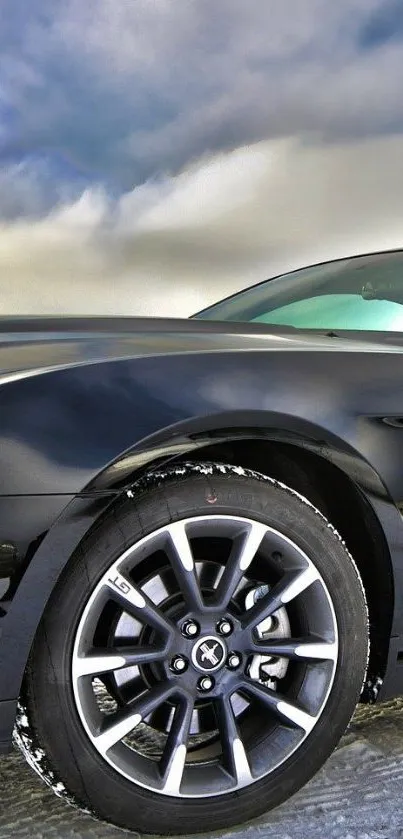 Sleek black sports car against cloudy sky.