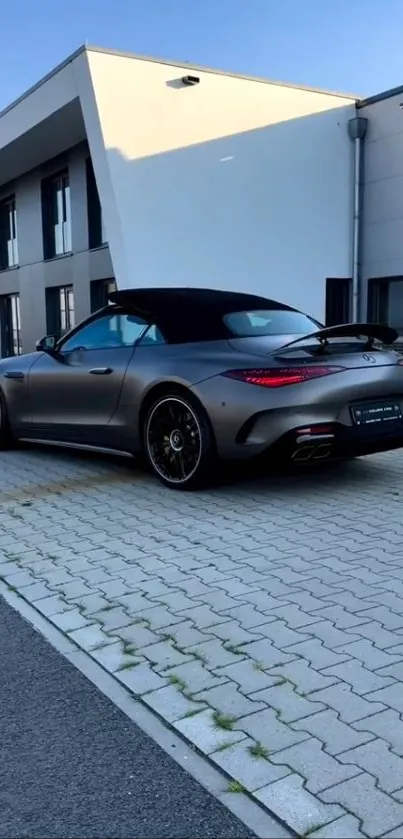 Sleek black sports car parked beside a modern building under clear sky.