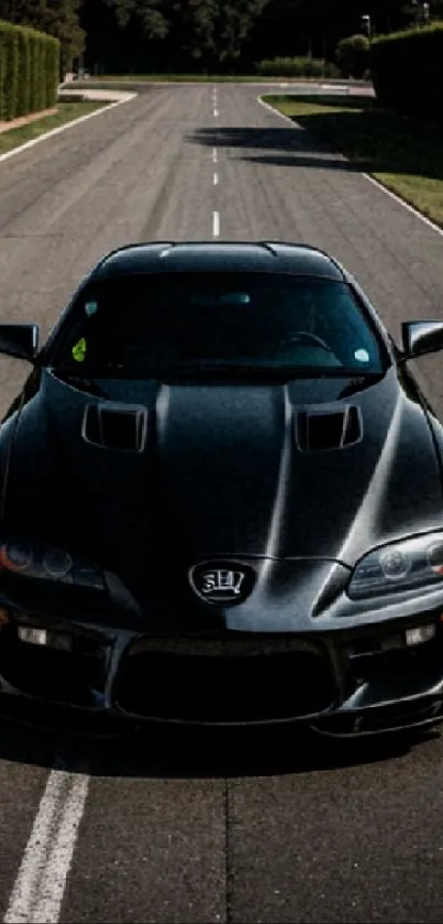 Sleek black sports car on the open road wallpaper.