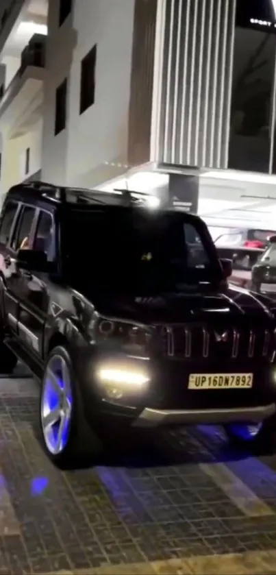 Sleek black SUV parked at night in urban setting.