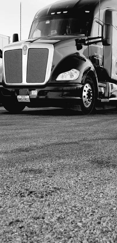 Sleek black truck on asphalt road with industrial backdrop.