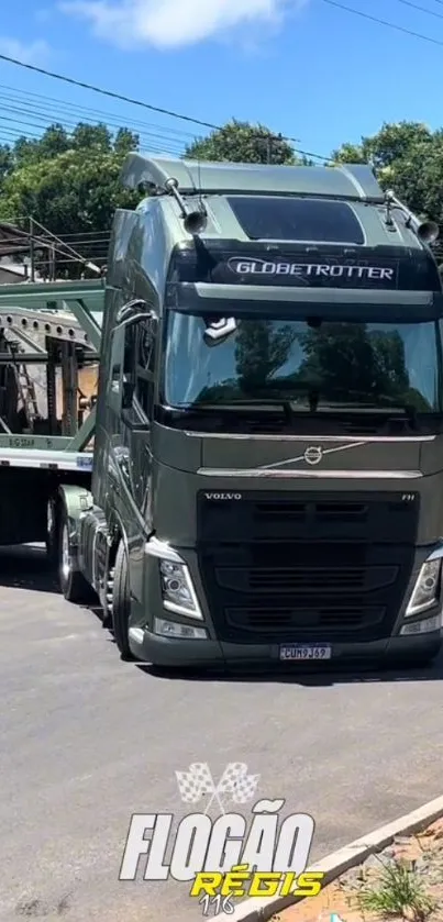 Black semi truck on road with a trailer in a sunny outdoor setting.